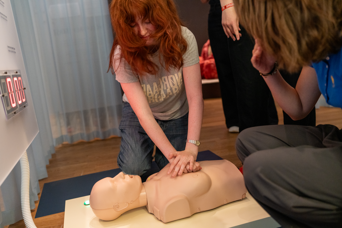 Visitor trying a female CPR training manikin